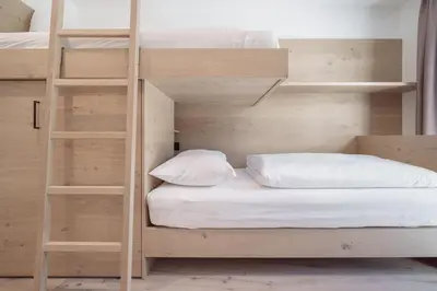 a bedroom with bunk beds with white pillows at Villa Rames in Ortisei