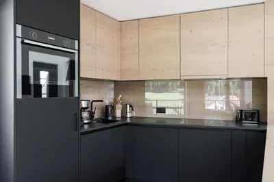 a kitchen with black appliances and wooden cabinets at Villa Rames in Ortisei