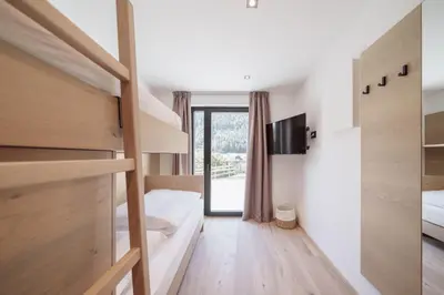 a bedroom with two bunk beds and a tv at Villa Rames in Ortisei