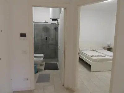 a bathroom with a shower and a bed and a toilet at Apartaments and Rooms Claudia Augusta in Bolzano