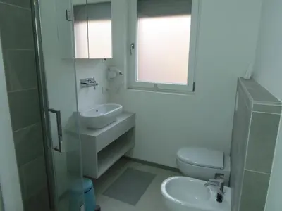 a bathroom with a sink and a toilet and a mirror at Apartaments and Rooms Claudia Augusta in Bolzano