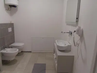 a white bathroom with a toilet and a sink at Apartaments and Rooms Claudia Augusta in Bolzano