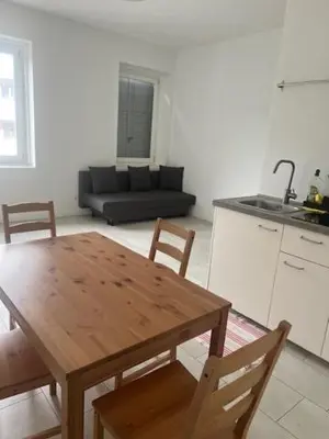 a table and chairs in a kitchen with a couch at Apartaments and Rooms Claudia Augusta in Bolzano