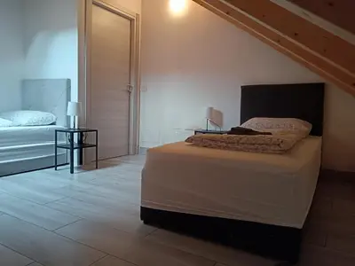 a bedroom with a large bed and a staircase at Apartaments and Rooms Claudia Augusta in Bolzano
