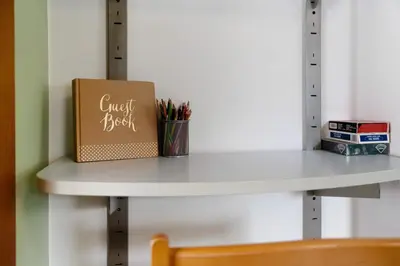 a book sitting on a white shelf with a chair at Casa Maria Beatrice in Mühlbach