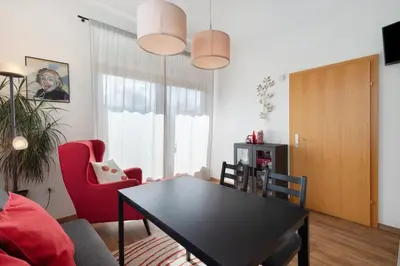 a living room with a black table and red chairs at Casa Maria Beatrice in Mühlbach