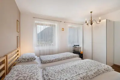 a bedroom with two beds and a chandelier at Casa Maria Beatrice in Mühlbach