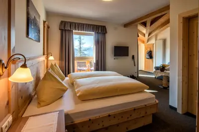 a bedroom with a large bed and a window at Hotel Landgasthof Lärchenwald in Collepietra
