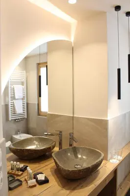 two sinks on a wooden counter in a bathroom at Hotel Landgasthof Lärchenwald in Collepietra