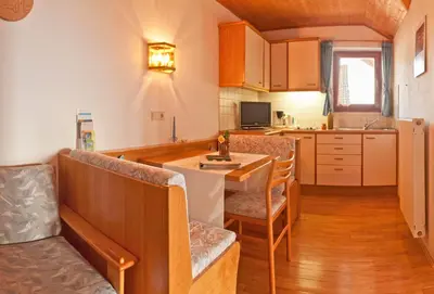 a kitchen with a table and chairs in a room at Gfillhof Ferienwohnung 1 in Appiano sulla Strada del Vino