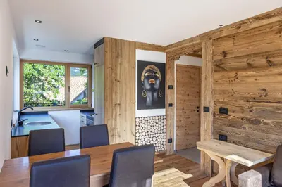 a dining room with wooden walls and a table and chairs at Chalet Berna in Ortisei