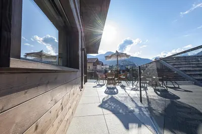 a balcony with tables and chairs on a building at Chalet Berna in Ortisei