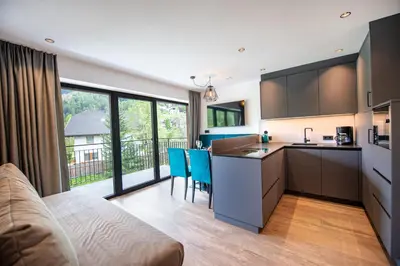 a kitchen and living room with a couch and a table at Apartments LaBar in Ortisei