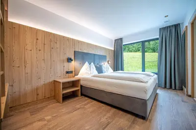 a bedroom with a large bed and a large window at Apartments LaBar in Ortisei