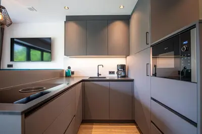 a kitchen with brown cabinets and a sink at Apartments LaBar in Ortisei