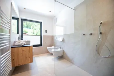 a bathroom with a shower and a toilet and a sink at Apartments LaBar in Ortisei