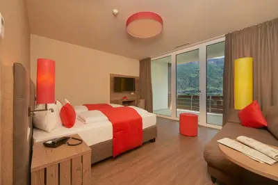 a hotel room with a bed and a couch at Hotel Gantkofel in Andrian