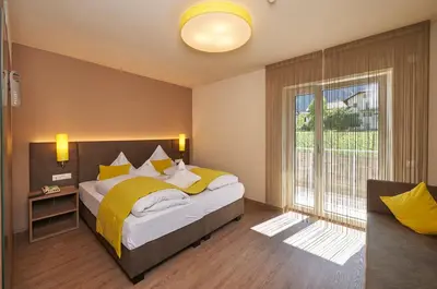 a bedroom with a bed with yellow sheets and a window at Hotel Gantkofel in Andrian
