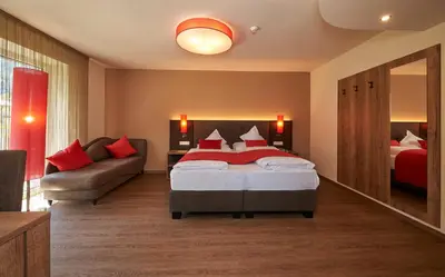 a hotel room with a bed and a couch at Hotel Gantkofel in Andrian
