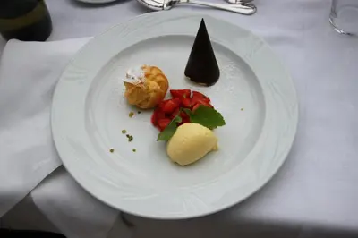 a white plate with food on a table at Hotel Gantkofel in Andrian