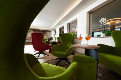 a room with green chairs and a table at Hotel Gantkofel in Andrian