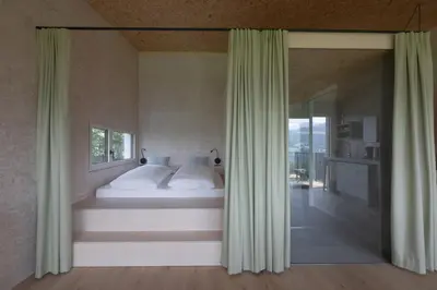 a bedroom with a bed with white sheets and a window at Das Baumhaus in Fiè