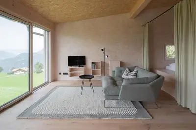 a living room with a couch and a large window at Das Baumhaus in Fiè