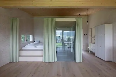 a bedroom with a bed and a large window at Das Baumhaus in Fiè