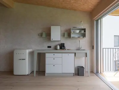 a kitchen with a white counter and a table at Das Baumhaus in Fiè