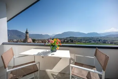 a living room with a green couch and a table at Villa Maria Boutique Apartment St Pauls in Appiano sulla Strada del Vino