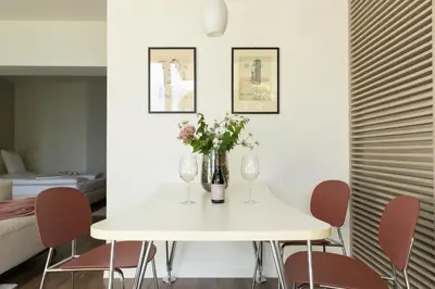 a white dining room table with wine glasses and flowers at Villa Hochland in Merano