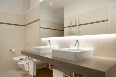 a bathroom with two sinks and a toilet at Villa Hochland in Merano