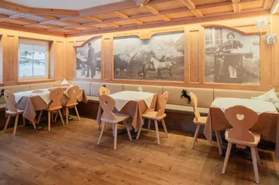 a dining room with tables and chairs and a painting at B&B Agriturismo Cèsa Ciasates in Canazei