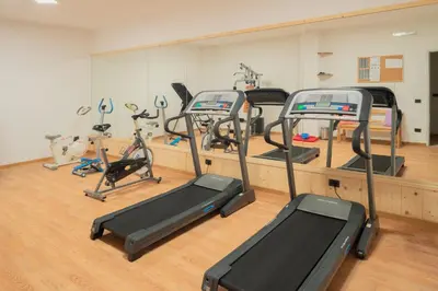 a gym with several tread machines in a room at B&B Agriturismo Cèsa Ciasates in Canazei
