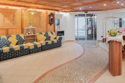 a large living room with couches and a rug at B&B Agriturismo Cèsa Ciasates in Canazei