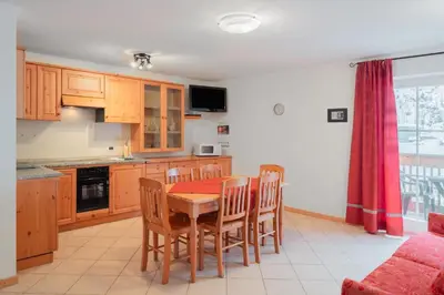 a kitchen with a wooden table and chairs in a room at Appartamenti Agriturismo Cèsa Ciasates in Canazei