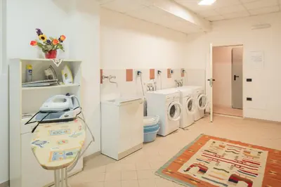 a laundry room with washing machines and a sink at Appartamenti Agriturismo Cèsa Ciasates in Canazei