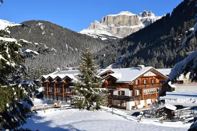a lodge in the mountains with snow on the ground at Appartamenti Agriturismo Cèsa Ciasates in Canazei