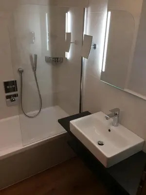 a white bathroom with a sink and a shower at Residence Soel in Selva di Val Gardena