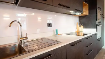 a kitchen with a stainless steel sink and a counter at Appartamento Vale e Schena Cortina D'Ampezzo in San Vito di Cadore
