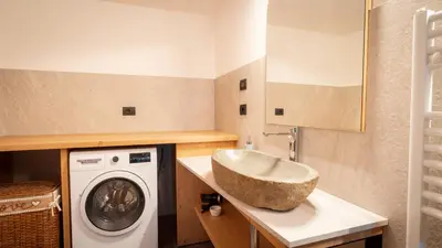 a bathroom with a sink and a washing machine at Appartamento Vale e Schena Cortina D'Ampezzo in San Vito di Cadore