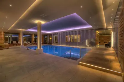 a swimming pool in the middle of a house at Hotel Aaritz in Selva di Val Gardena
