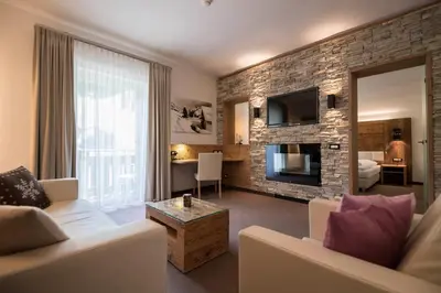 a living room with a couch and a fireplace at Hotel Aaritz in Selva di Val Gardena