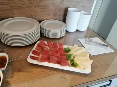 a plate of watermelon and cheese on a table with plates at Affittacamere Mercedes in Romallo