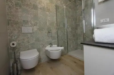a bathroom with a toilet and a glass shower at Affittacamere Mercedes in Romallo