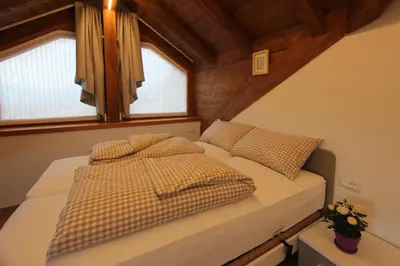 a bedroom with two beds and two windows at Affittacamere Mercedes in Romallo