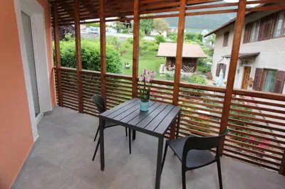 a wooden table and chairs on a balcony at Affittacamere Mercedes in Romallo