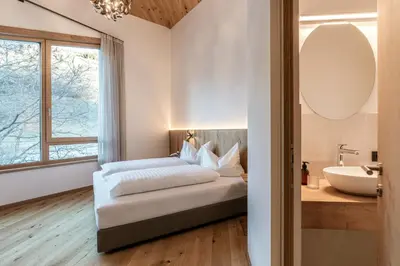 a bedroom with a bed and a sink and a mirror at Chalet Samont in Laion