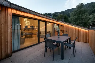 a patio with a table and chairs on a balcony at Chalet Samont in Laion
