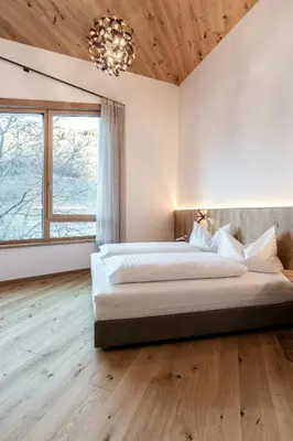 a bedroom with a large bed and a chandelier at Chalet Samont in Laion